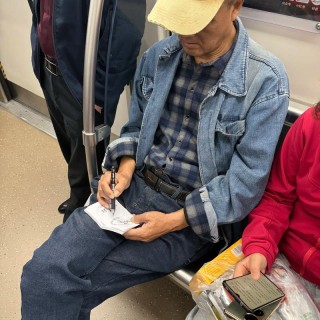 地铁里收报纸的老人